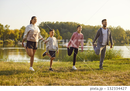 Healthy, sporty mother, father and children doing active fitness exercises in nature Healthy, sporty mother, father and children doing active fitness exercises in nature 132334427