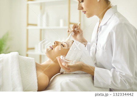 Young woman enjoying professional beauty procedures done by beautician at spa salon Young woman enjoying professional beauty procedures done by beautician at spa salon 132334442
