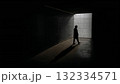 Silhouette Walking in a Dimly Lit Corridor of Shadows 132334571