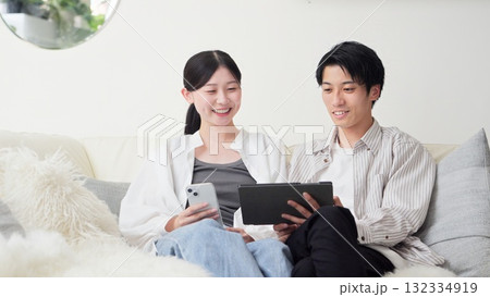 笑顔でタブレットを見るアジア人カップル 132334919
