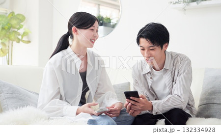 笑顔でスマホを見るアジア人カップル 笑顔でスマホを見るアジア人カップル 132334928