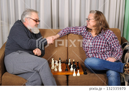 An elderly couple playing chess An elderly couple playing chess 132335970