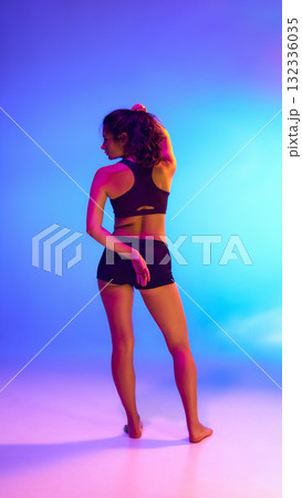 Back view of woman in sportwear under colorful light used for product packaging and activewear advertising Back view of woman in sportwear under colorful light used for product packaging and activewear advertising 132336035