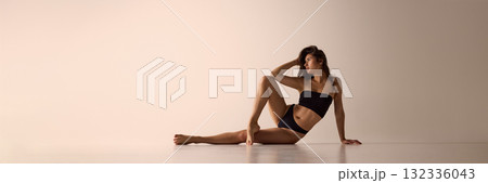Woman in black lingerie sitting on floor with elegant pose for modern underwear ads. Banner 132336043