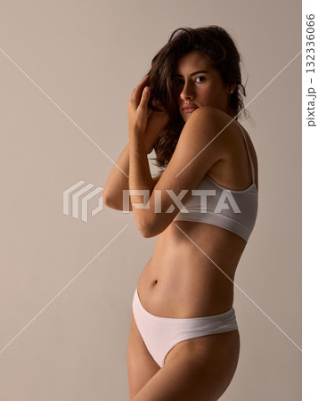 Portrait of woman in white underwear touching hair. Portrait of woman in white underwear touching hair. 132336066
