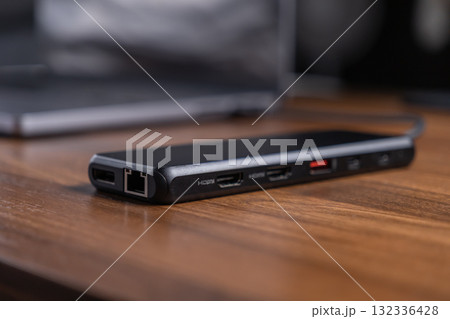 Black USB-C hub offering diverse expansion ports like HDMI and Ethernet, optimizing laptop connectivity and modern workflow for digital professionals 132336428