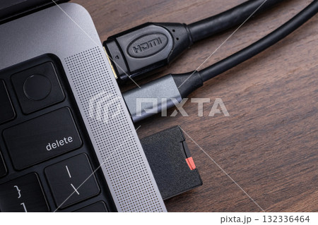 Sleek laptop featuring HDMI cable and memory card reader connections, representing essential digital device connectivity and efficient data transfer solutions 132336464