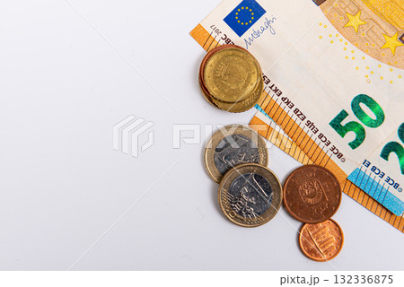 coins on the background of fifty euro banknotes, close-up, isolated on white 132336875