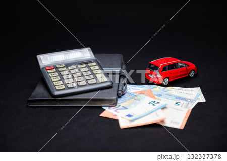 euro banknotes, calculator, notebook and red toy car on black background, insurance and loan concept euro banknotes, calculator, notebook and red toy car on black background, insurance and loan concept 132337378
