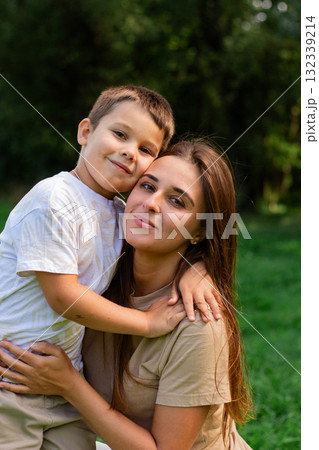 Image of happy mother and son outside in public park. Ideal for themes of parenting, motherhood and family relationships Image of happy mother and son outside in public park. Ideal for themes of parenting, motherhood and family relationships 132339214