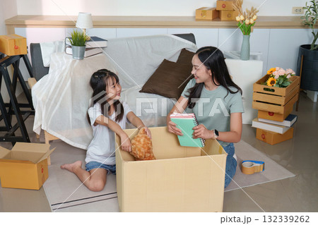 Unpacking joy. Mother and daughter organizing belongings in their new home. 132339262