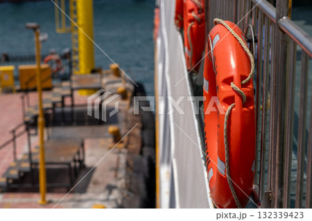 Lifebuoys attached to a boat docked near the Bosphorus in bright sunlight on a calm day, enhancing maritime safety 132339423