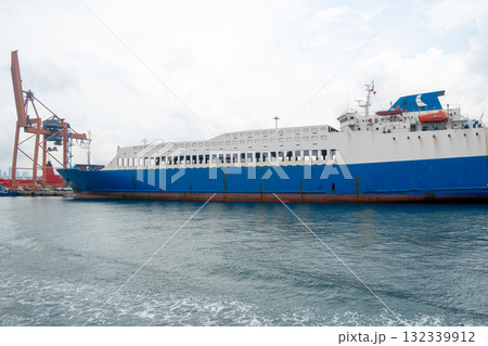 Bosphorus harbor activity with a large cargo ship and cranes on a cloudy day showcasing maritime transport 132339912