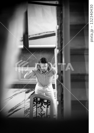 Woman adjusting her hair while standing near staircase in St. Petersburg during the day Woman adjusting her hair while standing near staircase in St. Petersburg during the day 132340430