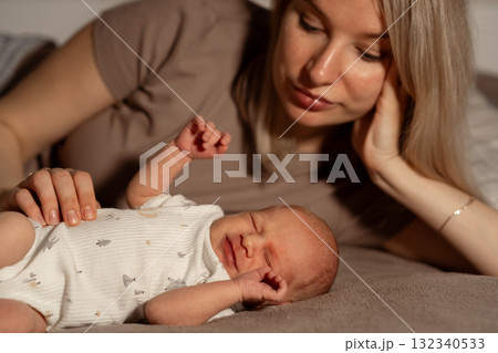 Mom enjoys precious moment with her newborn baby during peaceful evening at home 132340533