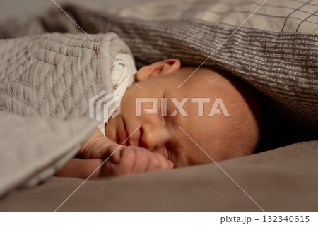 Peaceful moment between mother and sleeping baby in cozy bedding 132340615