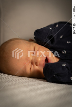 Baby sleeping peacefully on a soft blanket in a cozy indoor setting during the afternoon 132340625