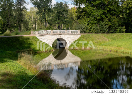 Scenic view of the Great Catherine Palace park featuring a beautiful stone bridge and serene water reflection Scenic view of the Great Catherine Palace park featuring a beautiful stone bridge and serene water reflection 132340895