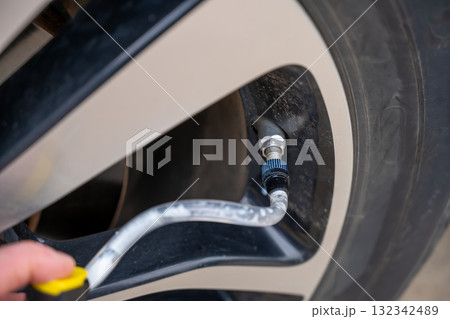 Selective focus on chemical additive sprayed from a can into a tire to fix a flat Selective focus on chemical additive sprayed from a can into a tire to fix a flat 132342489