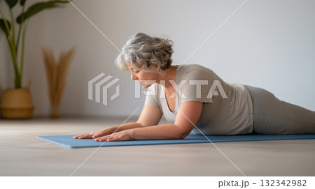Mature woman practicing yoga for wellness at home 132342982