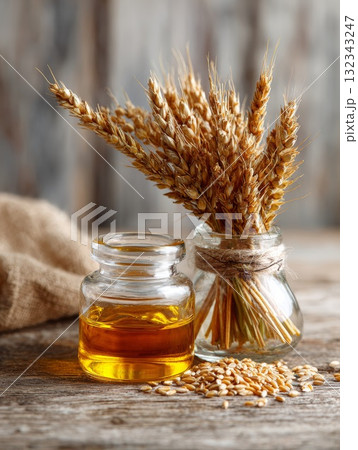 Bundle of wheat ears beside glass jar of oil on rustic wooden table, symbolizing isolation and exclusion 132343247