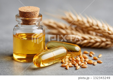 Golden capsule and wheat grain beside glass bottle of oil representing isolation and exclusion 132343249
