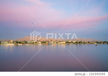 Hot Air Balloons Float Over West Bank of Luxor Egypt at Dawn from Nile Cruise. 132343345