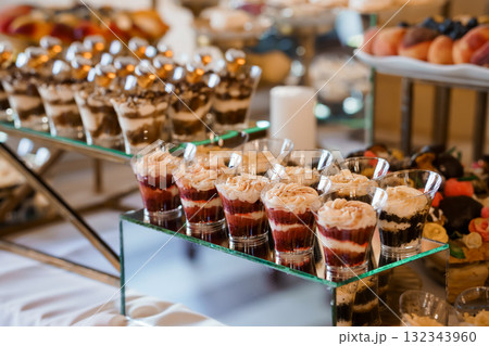 Elegant Dessert Display at Wedding Reception: Chocolate Mousse Parfaits, Glassware, Fruit Platter, Gold Accents, Luxurious Event Catering Style 132343960