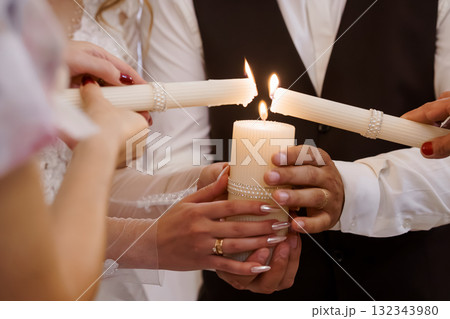 Wedding Candle Lighting Ceremony: Hands Holding Flames, Unity Ritual, White Candles, Elegant Celebration, Warm Light, Romantic Atmosphere, Close-Up Shot Wedding Candle Lighting Ceremony: Hands Holding Flames, Unity Ritual, White Candles, Elegant Celebration, Warm Light, Romantic Atmosphere, Close-Up Shot 132343980