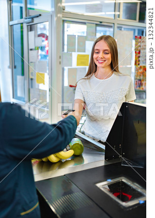 Smiling customer enjoys shopping experience at grocery store checkout 132344821