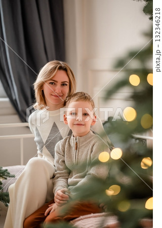 Mother and Son Smiling Together by Christmas Tree Mother and Son Smiling Together by Christmas Tree 132346218