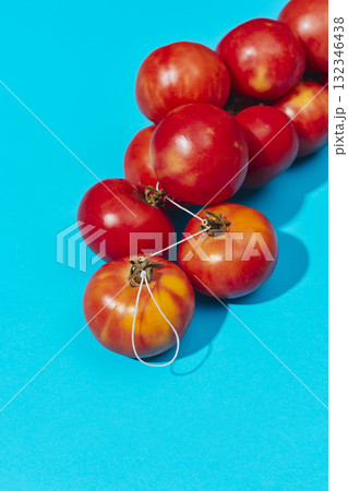 red tomatoes resting on a blue background 132346438