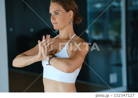 Woman practicing yoga poses in a bright studio during daytime while focusing on inner peace and mindfulness Woman practicing yoga poses in a bright studio during daytime while focusing on inner peace and mindfulness 132347127
