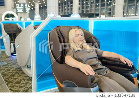 Comfortable relaxation experience at a modern wellness center during a sunny day while enjoying a massage chair Comfortable relaxation experience at a modern wellness center during a sunny day while enjoying a massage chair 132347139