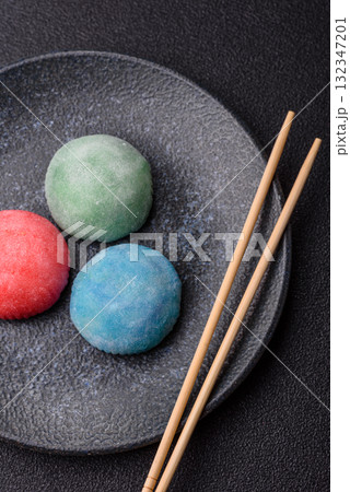 Japanese mochi, ice cream or Asian sweets with fruit filling. Mochi of different colors Japanese mochi, ice cream or Asian sweets with fruit filling. Mochi of different colors 132347201