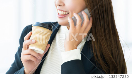 スマートフォンで話す笑顔の女性・ビジネスウーマン スマートフォンで話す笑顔の女性・ビジネスウーマン 132347280