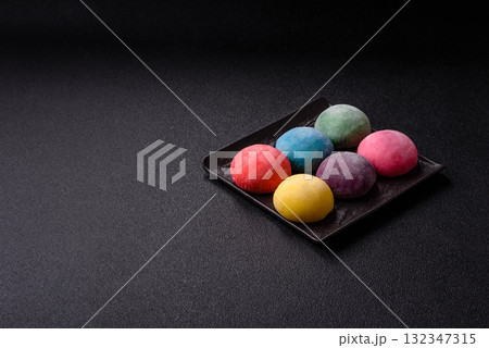 Japanese mochi, ice cream or Asian sweets with fruit filling. Mochi of different colors 132347315