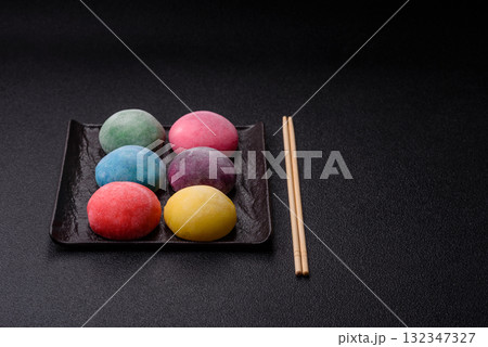 Japanese mochi, ice cream or Asian sweets with fruit filling. Mochi of different colors Japanese mochi, ice cream or Asian sweets with fruit filling. Mochi of different colors 132347327