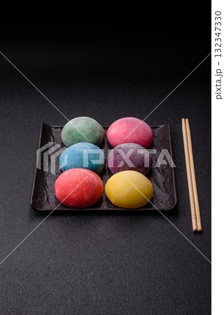 Japanese mochi, ice cream or Asian sweets with fruit filling. Mochi of different colors 132347330