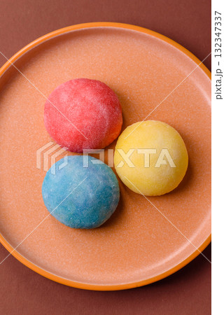 Japanese mochi, ice cream or Asian sweets with fruit filling. Mochi of different colors Japanese mochi, ice cream or Asian sweets with fruit filling. Mochi of different colors 132347337