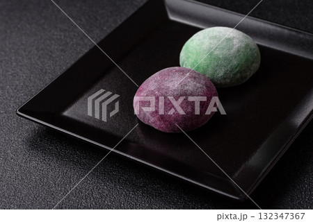Japanese mochi, ice cream or Asian sweets with fruit filling. Mochi of different colors Japanese mochi, ice cream or Asian sweets with fruit filling. Mochi of different colors 132347367