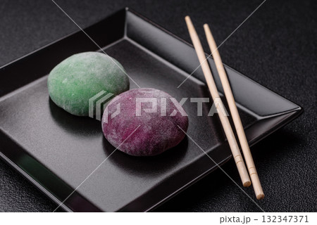 Japanese mochi, ice cream or Asian sweets with fruit filling. Mochi of different colors 132347371