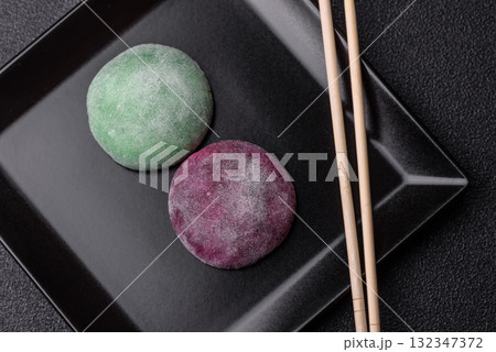 Japanese mochi, ice cream or Asian sweets with fruit filling. Mochi of different colors 132347372