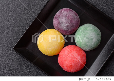 Japanese mochi, ice cream or Asian sweets with fruit filling. Mochi of different colors 132347385