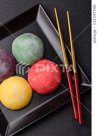 Japanese mochi, ice cream or Asian sweets with fruit filling. Mochi of different colors Japanese mochi, ice cream or Asian sweets with fruit filling. Mochi of different colors 132347390
