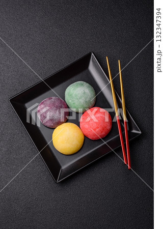 Japanese mochi, ice cream or Asian sweets with fruit filling. Mochi of different colors Japanese mochi, ice cream or Asian sweets with fruit filling. Mochi of different colors 132347394
