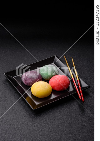 Japanese mochi, ice cream or Asian sweets with fruit filling. Mochi of different colors Japanese mochi, ice cream or Asian sweets with fruit filling. Mochi of different colors 132347395