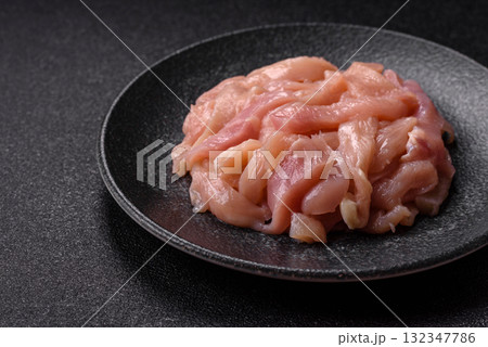 Raw chicken meat cut into strips, fresh fillet or breast slices. Chicken raw meat in pieces Raw chicken meat cut into strips, fresh fillet or breast slices. Chicken raw meat in pieces 132347786