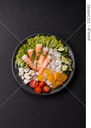 Bowl with shrimps, seafood, rice, oranges, tomatoes with sauce. Bowl with prawns 132348082