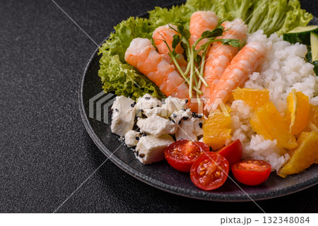 Bowl with shrimps, seafood, rice, oranges, tomatoes with sauce. Bowl with prawns 132348084